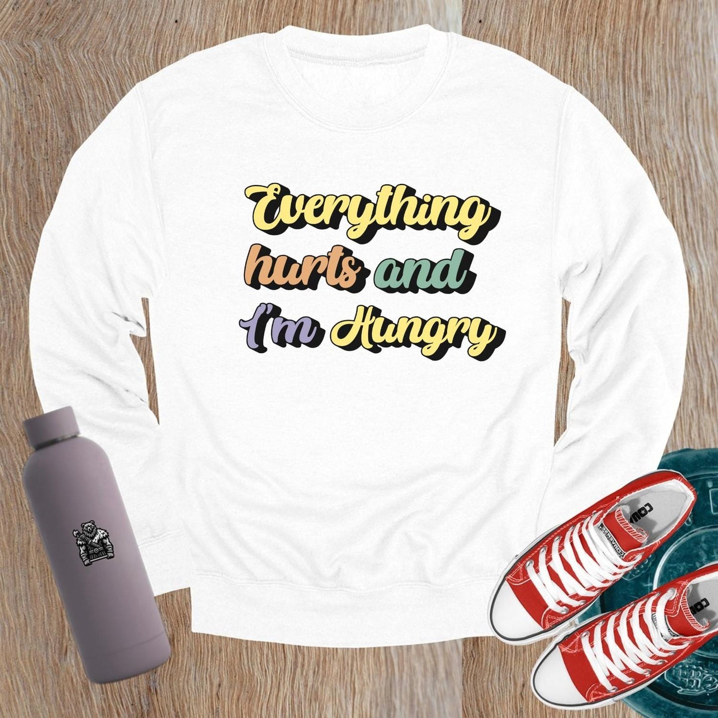 "Stylish crewneck sweatshirt featuring 'Everything hurts and I’m Hungry' slogan, perfect for gym enthusiasts embracing fitness humor."