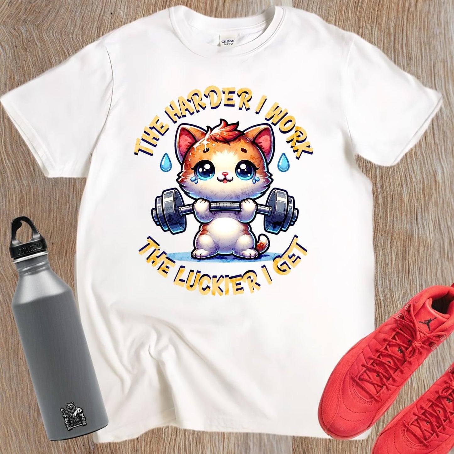 "Vibrant gym T-shirt featuring a determined kitty lifting weights, inspiring fitness enthusiasts with playful motivation for workouts."