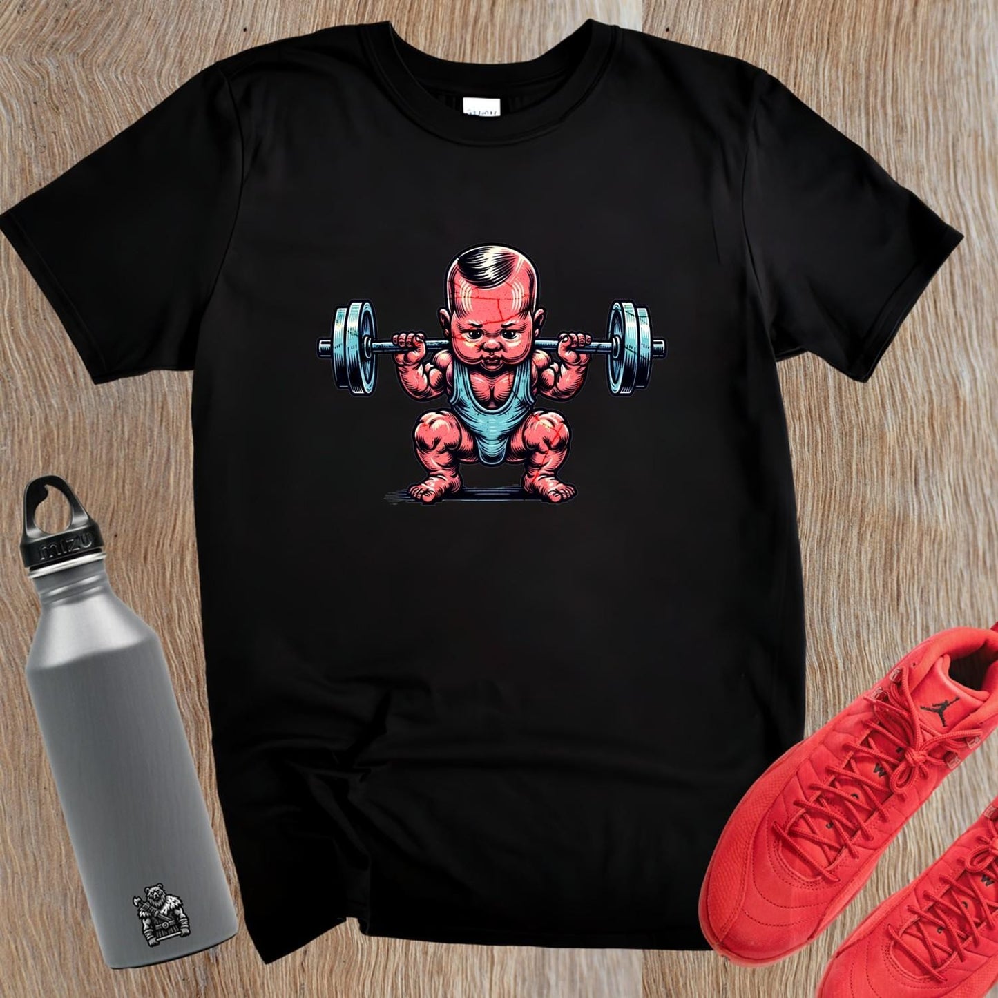 "Fun gym T-shirt featuring a charming baby lifting weights, combining humor and strength for fitness enthusiasts. Perfect for workouts!"
