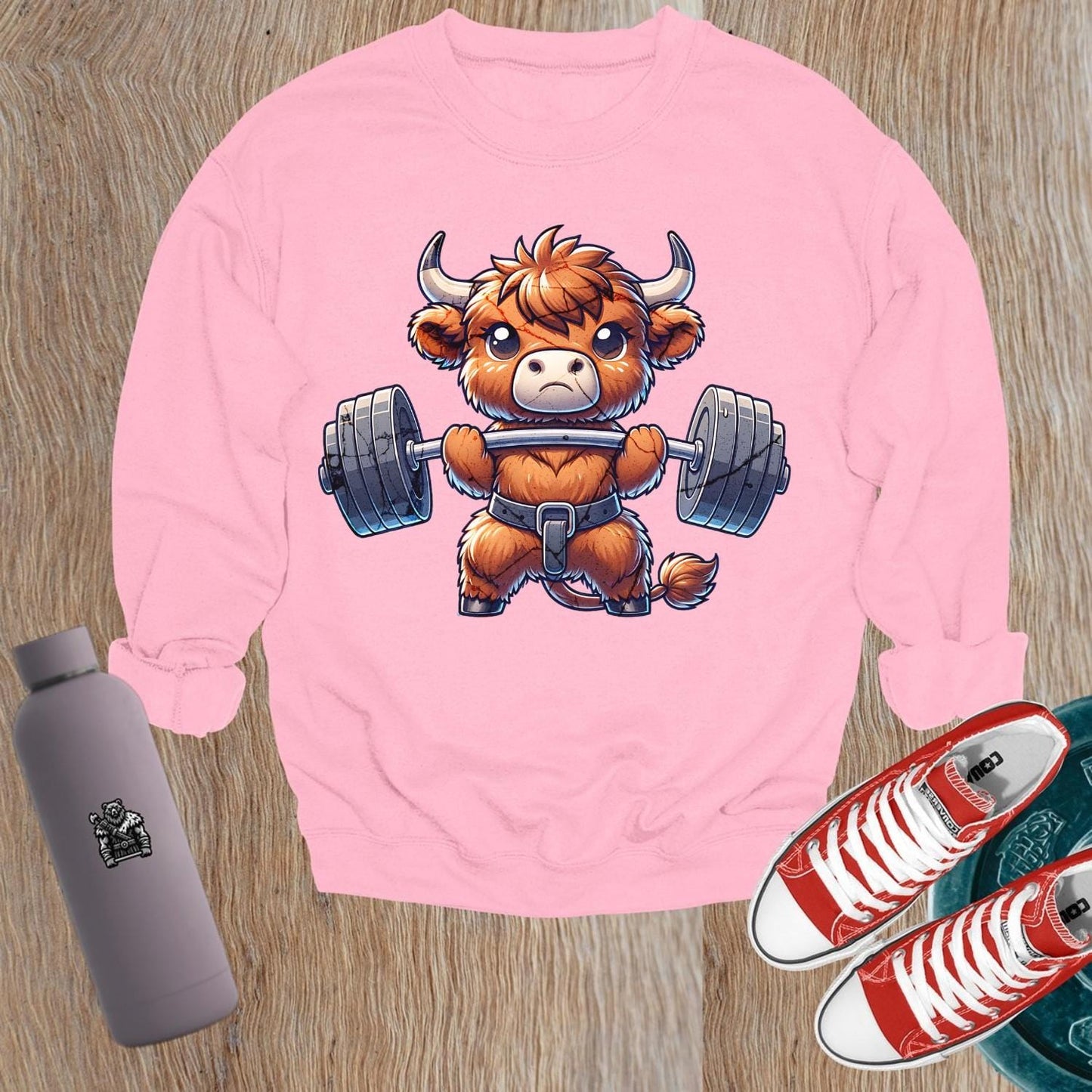 Alt text: "Vibrant gym sweatshirt featuring a cute highland cow lifting weights, promoting fitness goals and a healthy lifestyle. Perfect for workouts."