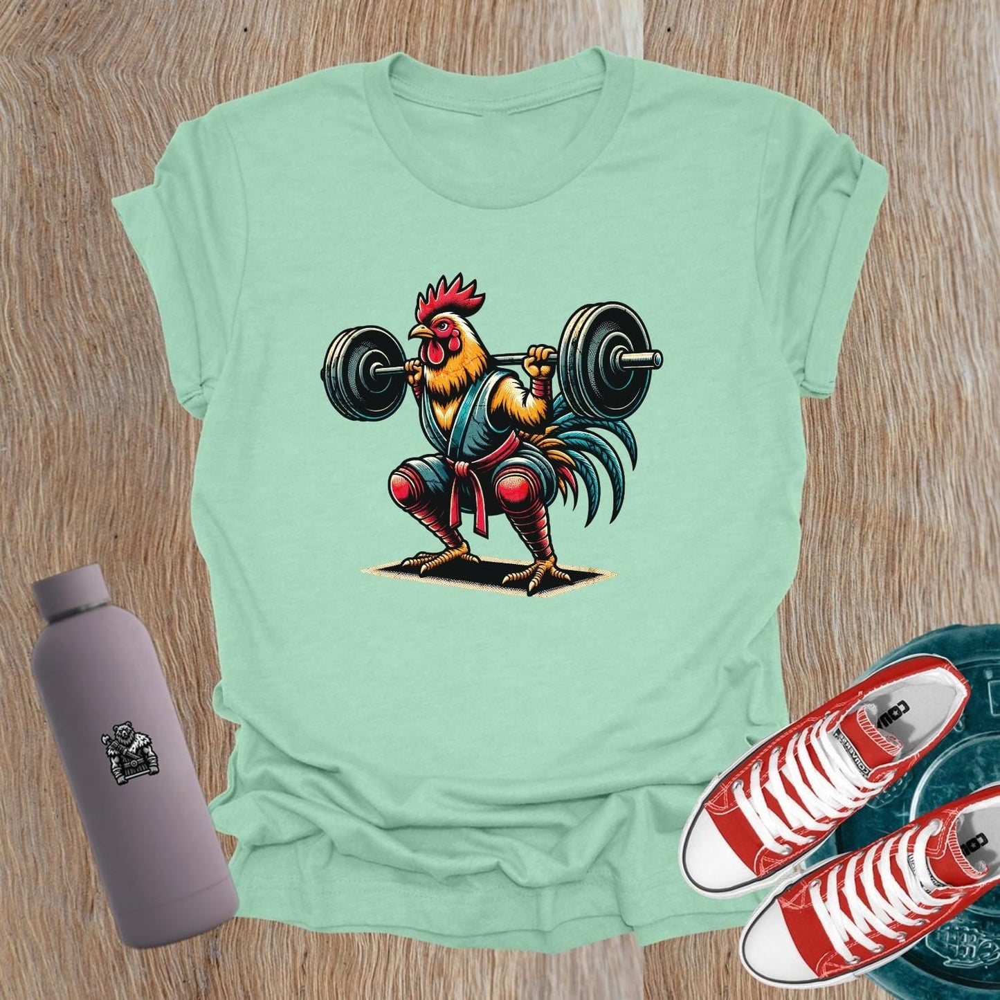Bold gym T-shirt featuring a fiercely squatting rooster, symbolizing empowerment and determination for women who lift weights.