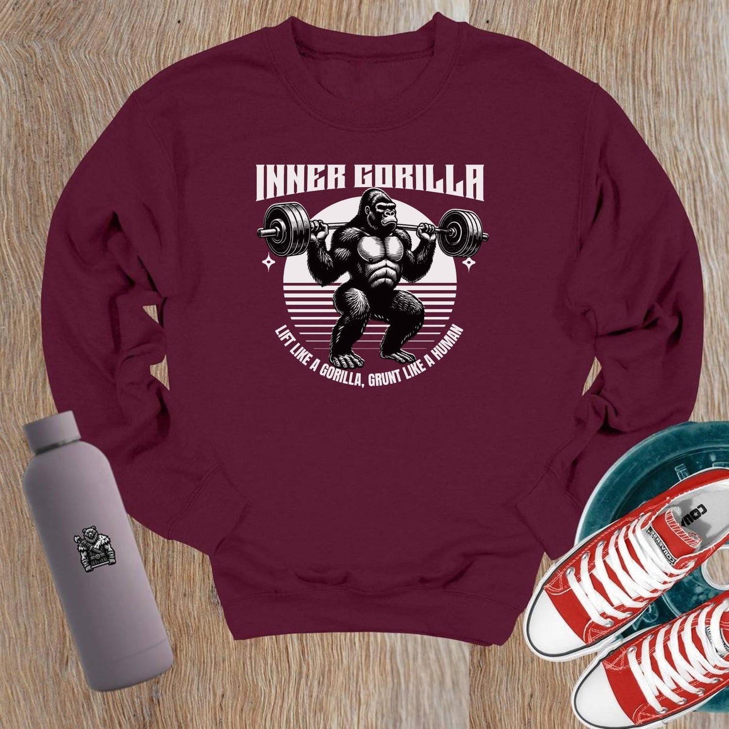 "Graphic crewneck sweatshirt featuring a powerful gorilla lifting weights with the motivational slogan 'Lift Like a Gorilla, Grunt Like a Human.' Ideal for fitness enthusiasts, this stylish gym apparel combines comfort and inspiration for workouts or casual wear."
