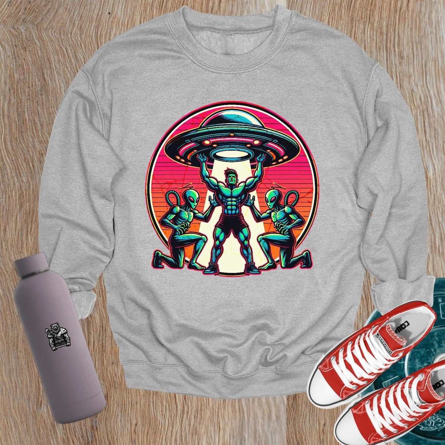 "Bold gym sweatshirt featuring a dynamic graphic of a muscular hero battling aliens, perfect for fitness enthusiasts and casual wear."