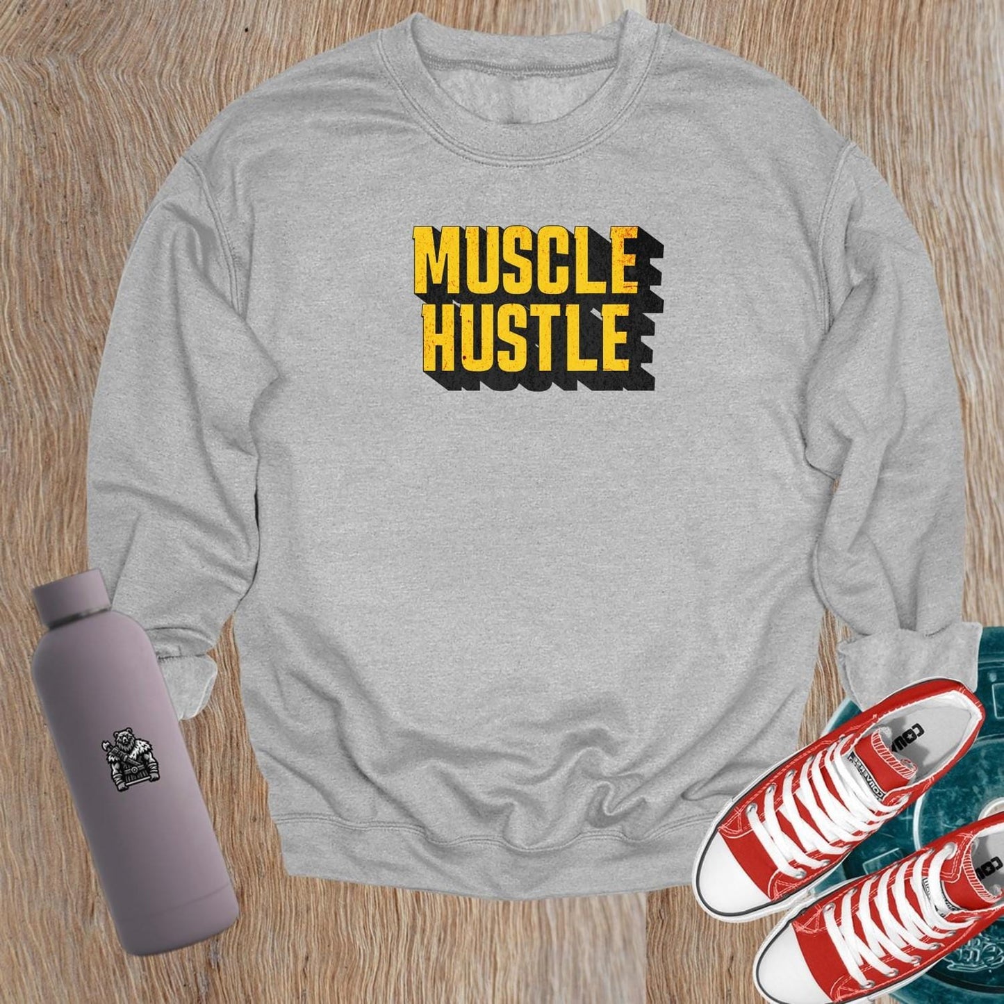 "Muscle Hustle sweatshirt featuring bold motivational graphic, designed for athletes. Perfect for workouts, errands, or lounging."