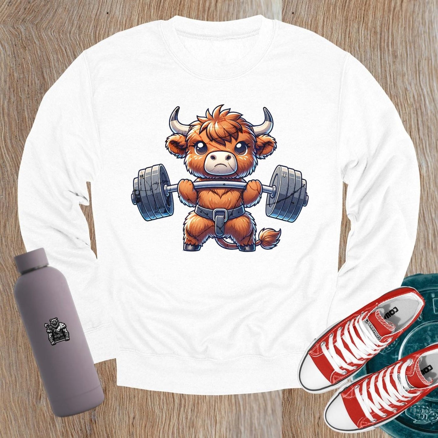Alt text: "Vibrant gym sweatshirt featuring a cute highland cow lifting weights, promoting fitness goals and a healthy lifestyle. Perfect for workouts."
