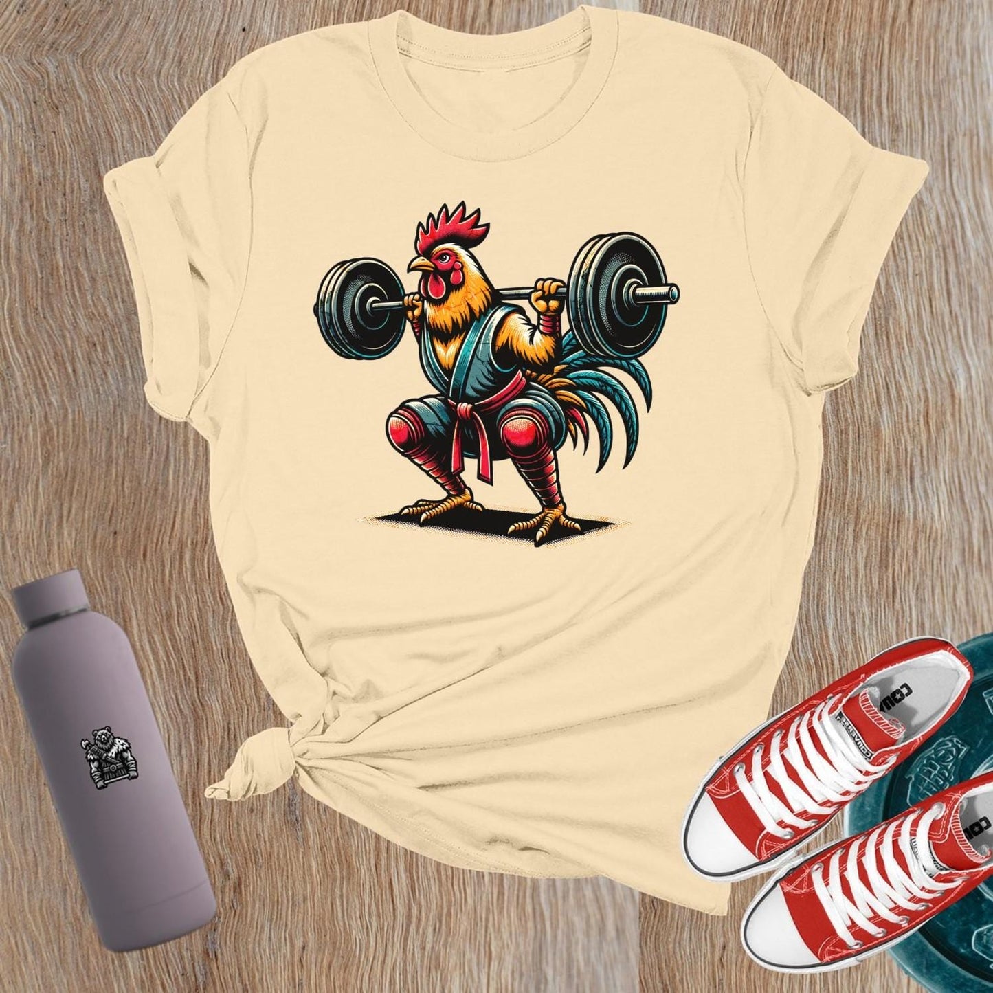 Bold gym T-shirt featuring a fiercely squatting rooster, symbolizing empowerment and determination for women who lift weights.