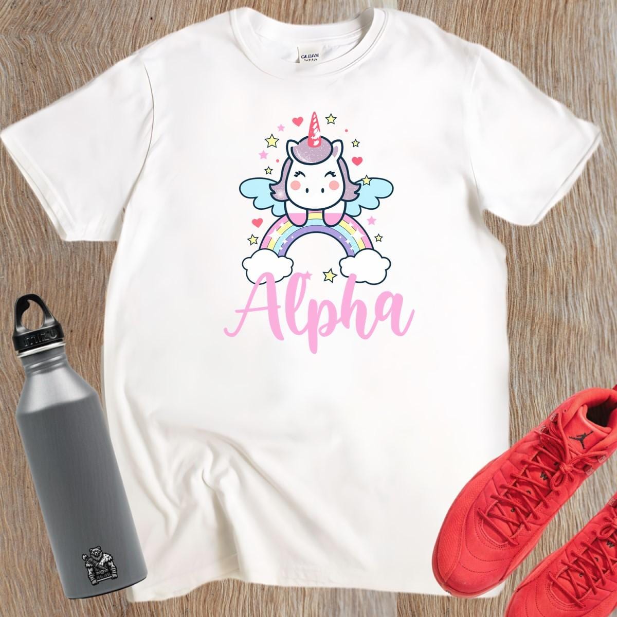 "Colorful Alpha T-shirt featuring a cute unicorn, rainbows, and sparkling stars, perfect for gym workouts and showcasing individuality."