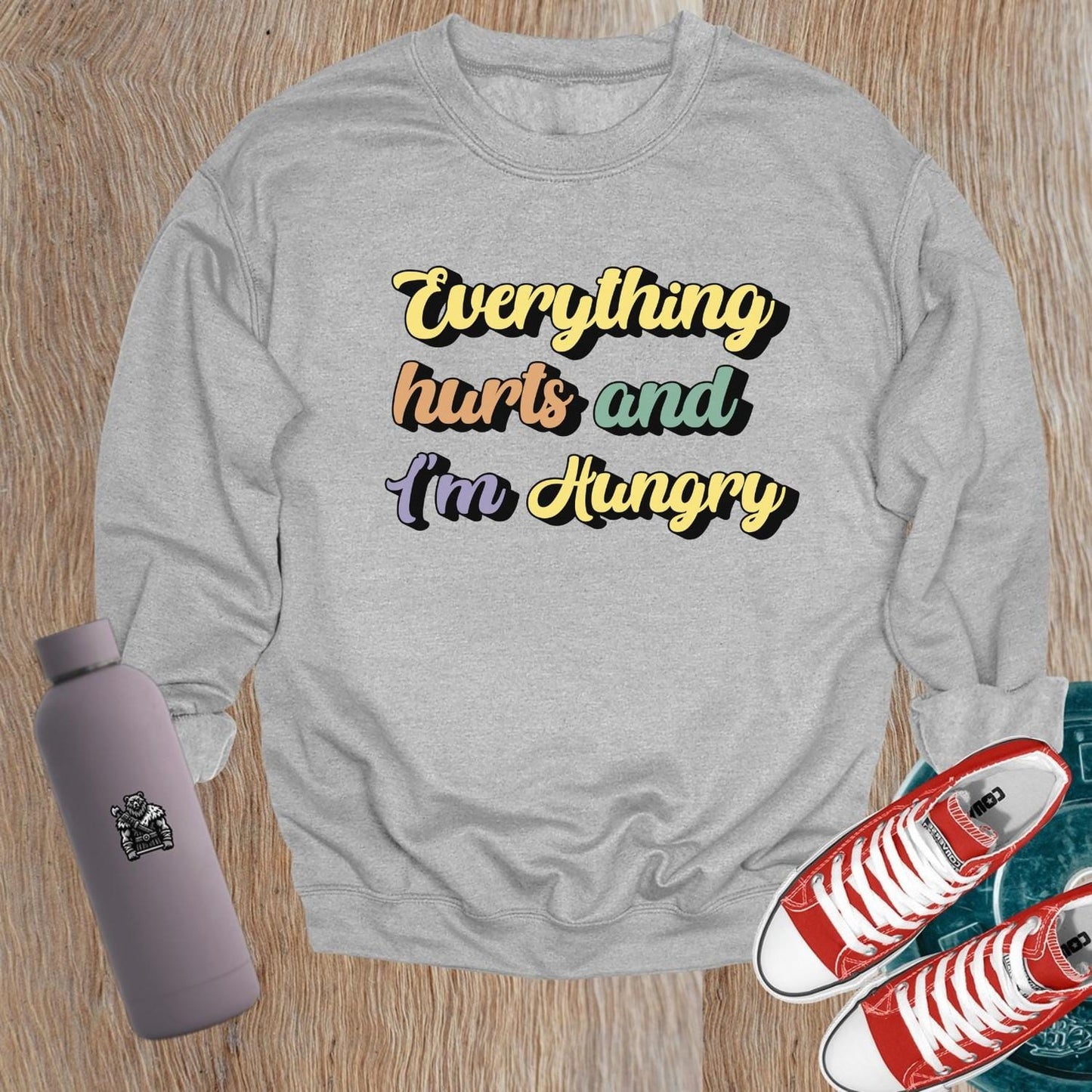 "Stylish crewneck sweatshirt featuring 'Everything hurts and I’m Hungry' slogan, perfect for gym enthusiasts embracing fitness humor."