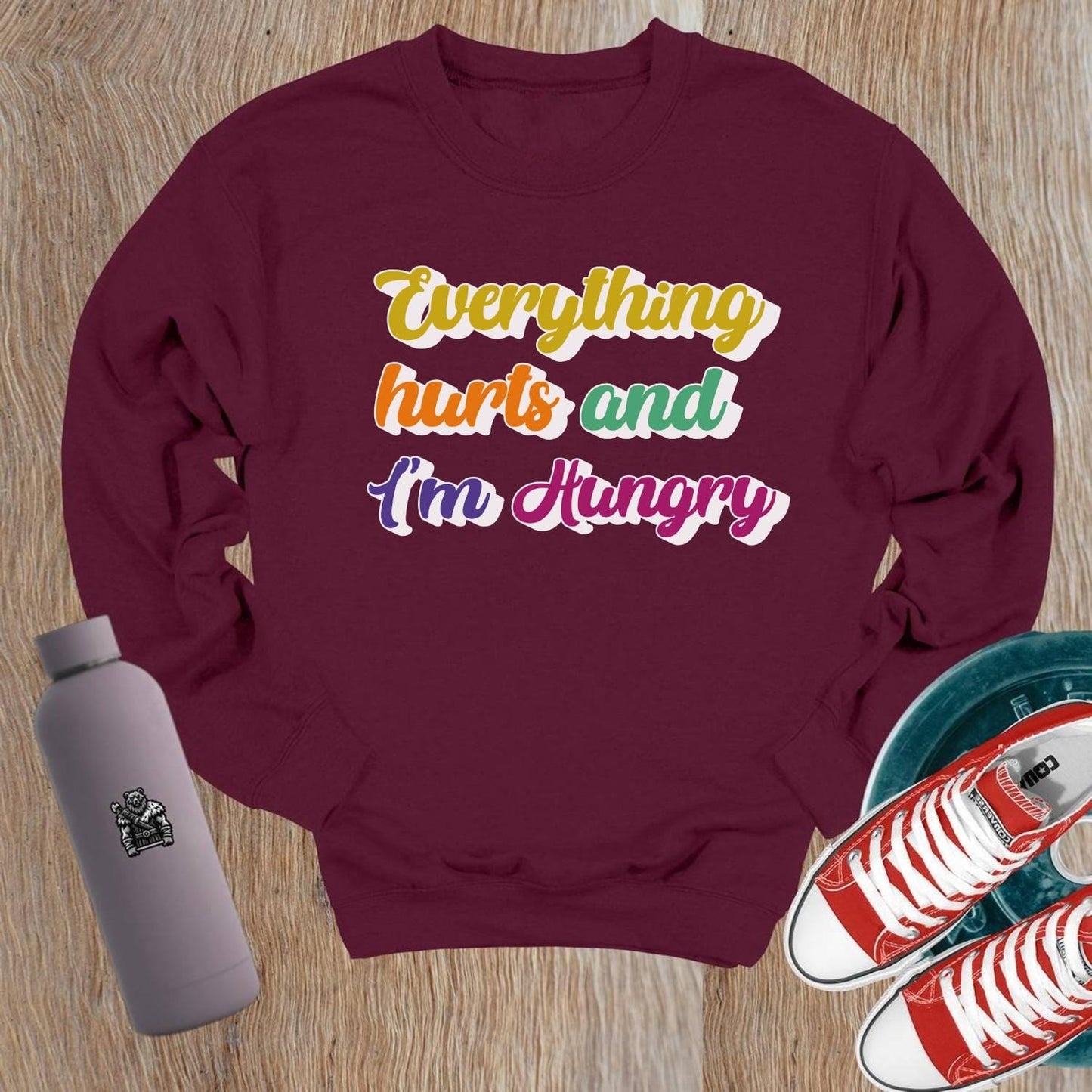 "Bold Crewneck Sweatshirt for gym-goers, featuring 'Everything hurts and I’m Hungry' in eye-catching design, perfect for workouts."