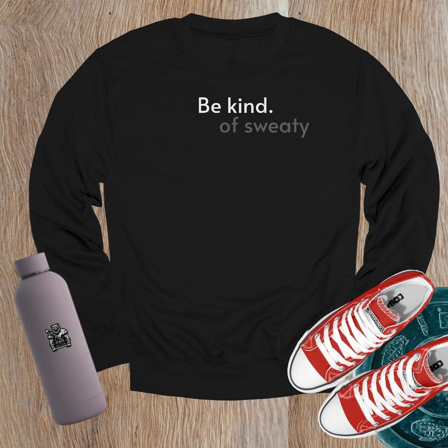 "Stylish crewneck sweatshirt with 'Be kind. of sweaty.' text, perfect for workouts or lounging; combines comfort and motivation."