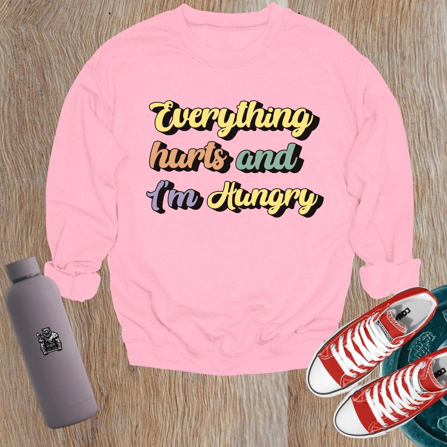 "Stylish crewneck sweatshirt featuring 'Everything hurts and I’m Hungry' slogan, perfect for gym enthusiasts embracing fitness humor."