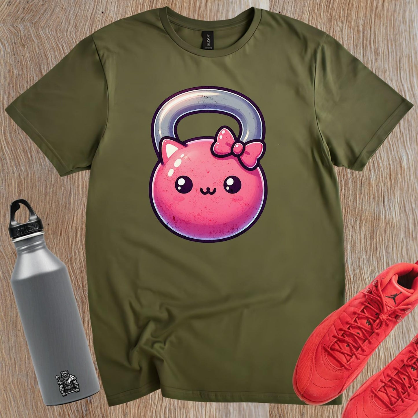 "Adorable pink kettlebell T-shirt with a cute cat face and bow, perfect for gym lovers. Stylish workout gear for fitness enthusiasts."