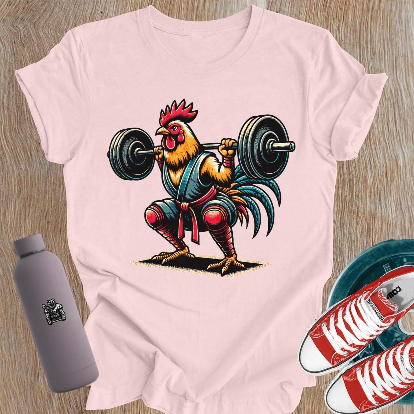 Bold gym T-shirt featuring a fiercely squatting rooster, symbolizing empowerment and determination for women who lift weights.