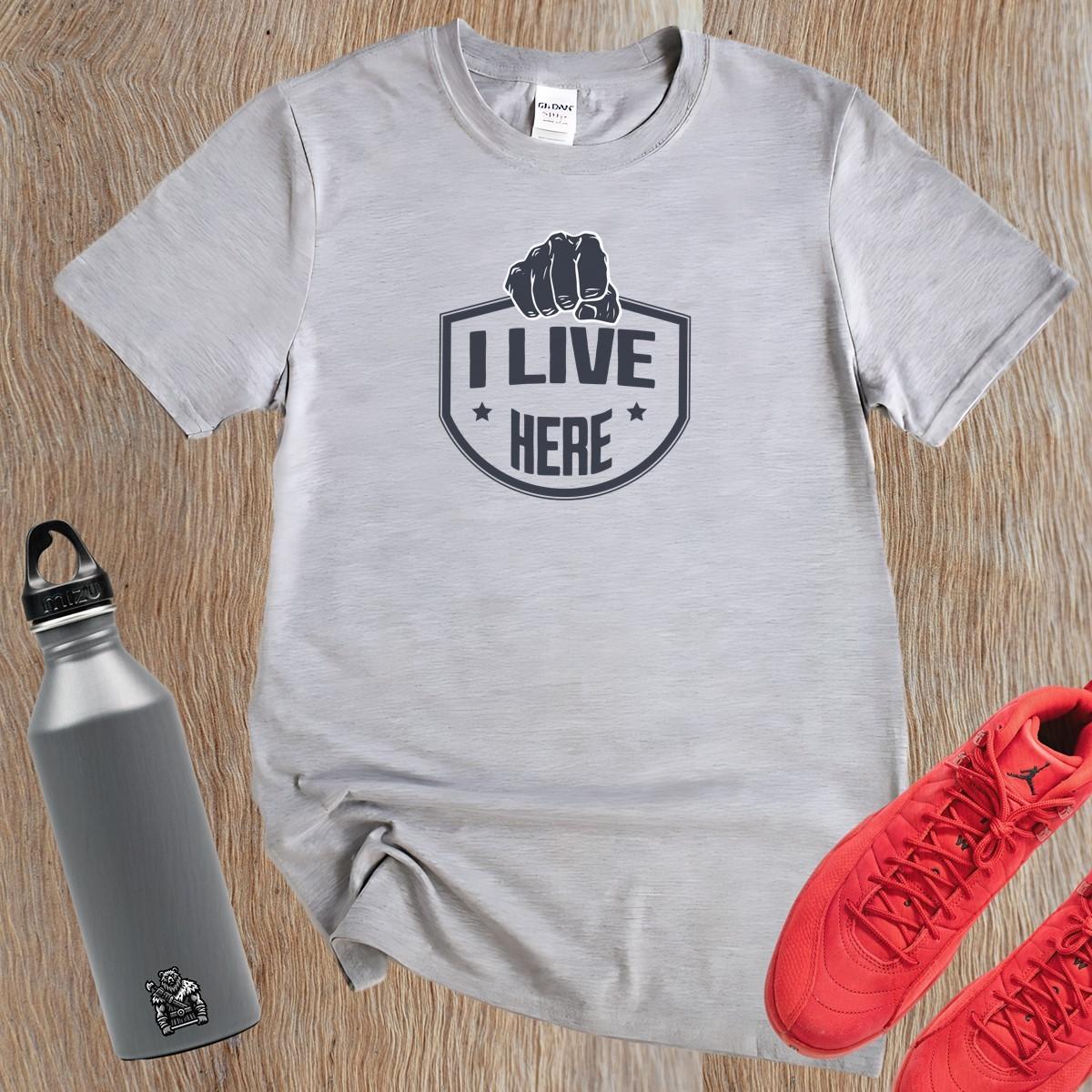 "Bold 'I Live Here' graphic tee for fitness enthusiasts, perfect for workouts and casual wear. Show your dedication to fitness!"