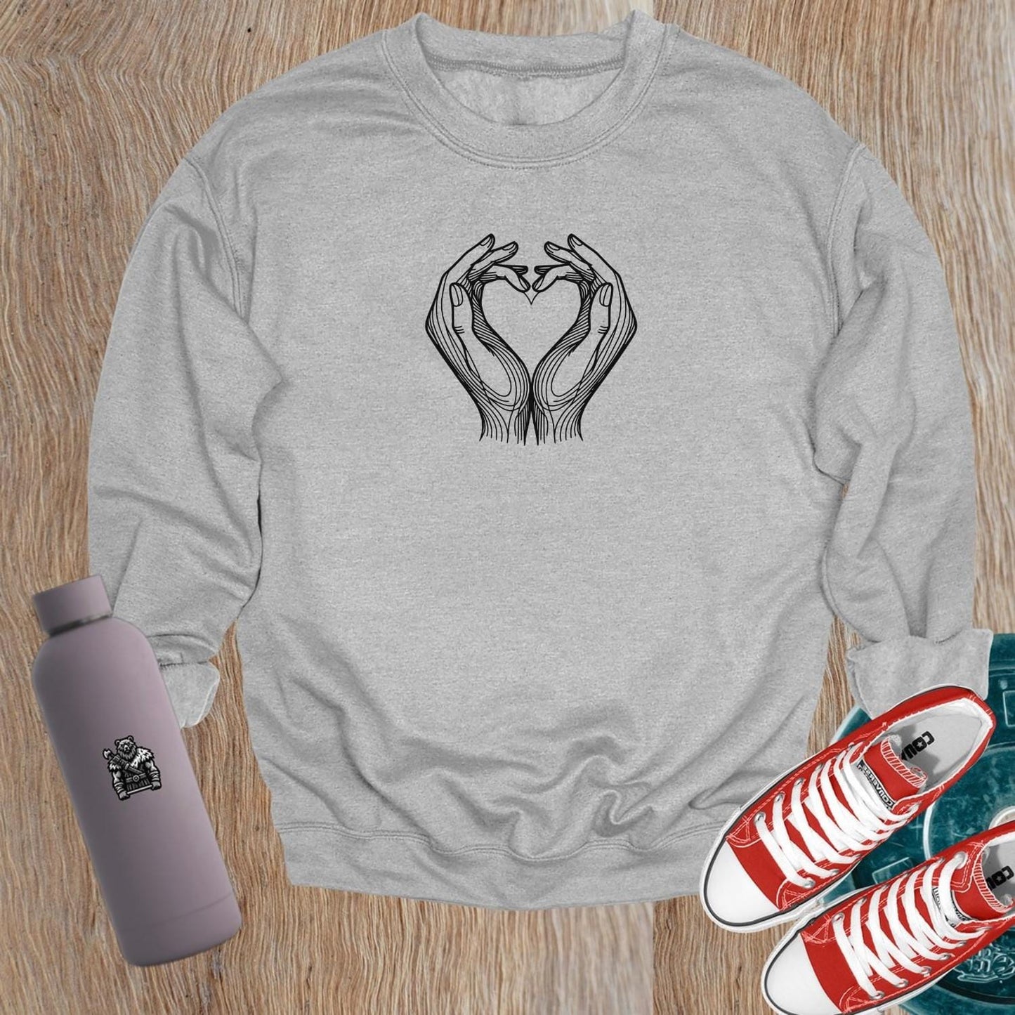 "Stylish gym sweatshirt featuring a heart formed by hands, perfect for fitness lovers. Comfortable, trendy activewear for workouts."
