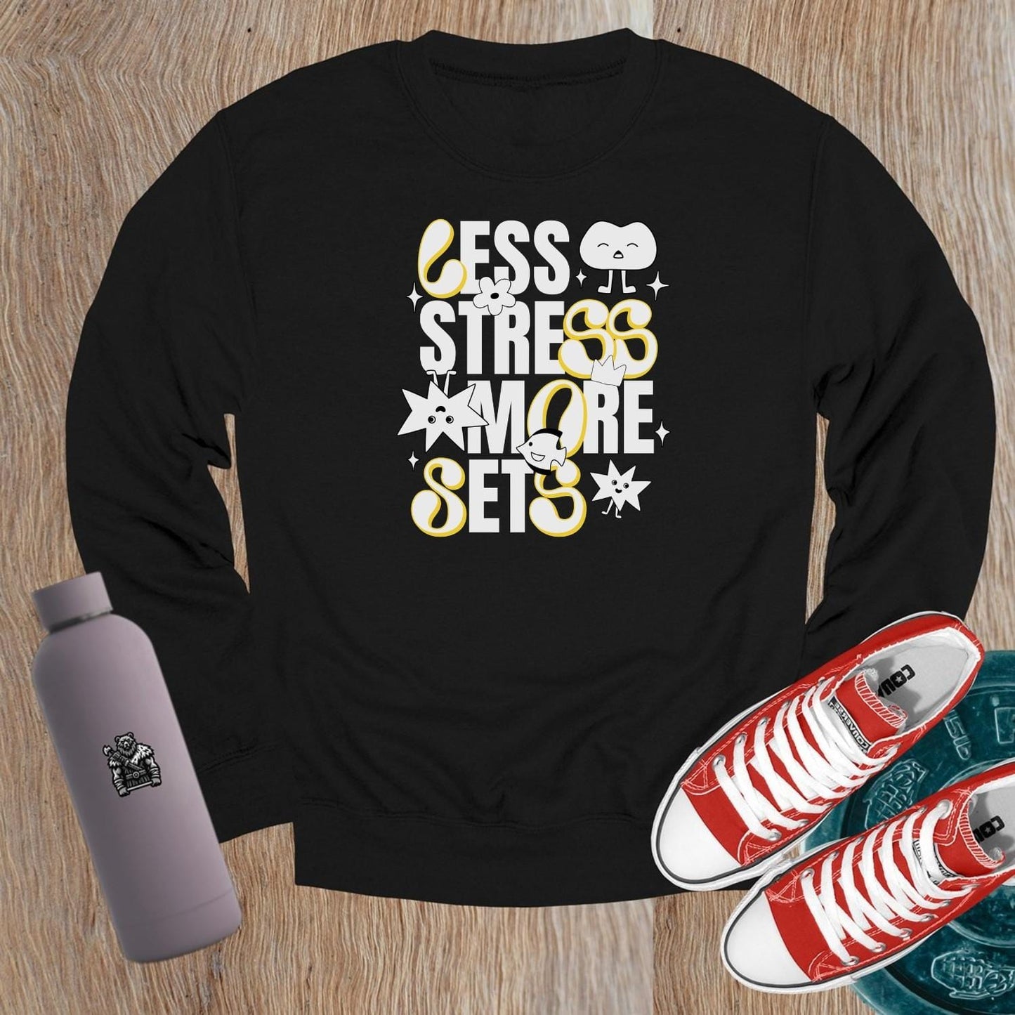 Alt text: "Vibrant crewneck sweatshirt with playful fitness graphics 'Less Stress, More Sets!' Perfect for gym workouts and casual wear."