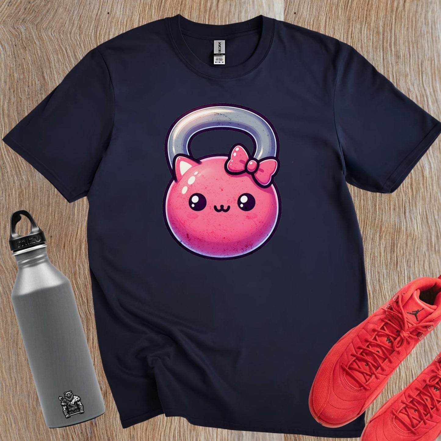"Adorable pink kettlebell T-shirt with a cute cat face and bow, perfect for gym lovers. Stylish workout gear for fitness enthusiasts."