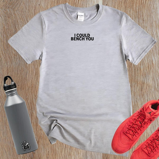 "Bold gym T-shirt with playful 'I Could Bench You' phrase, designed for active wear. Perfect for weightlifting and cardio workouts."