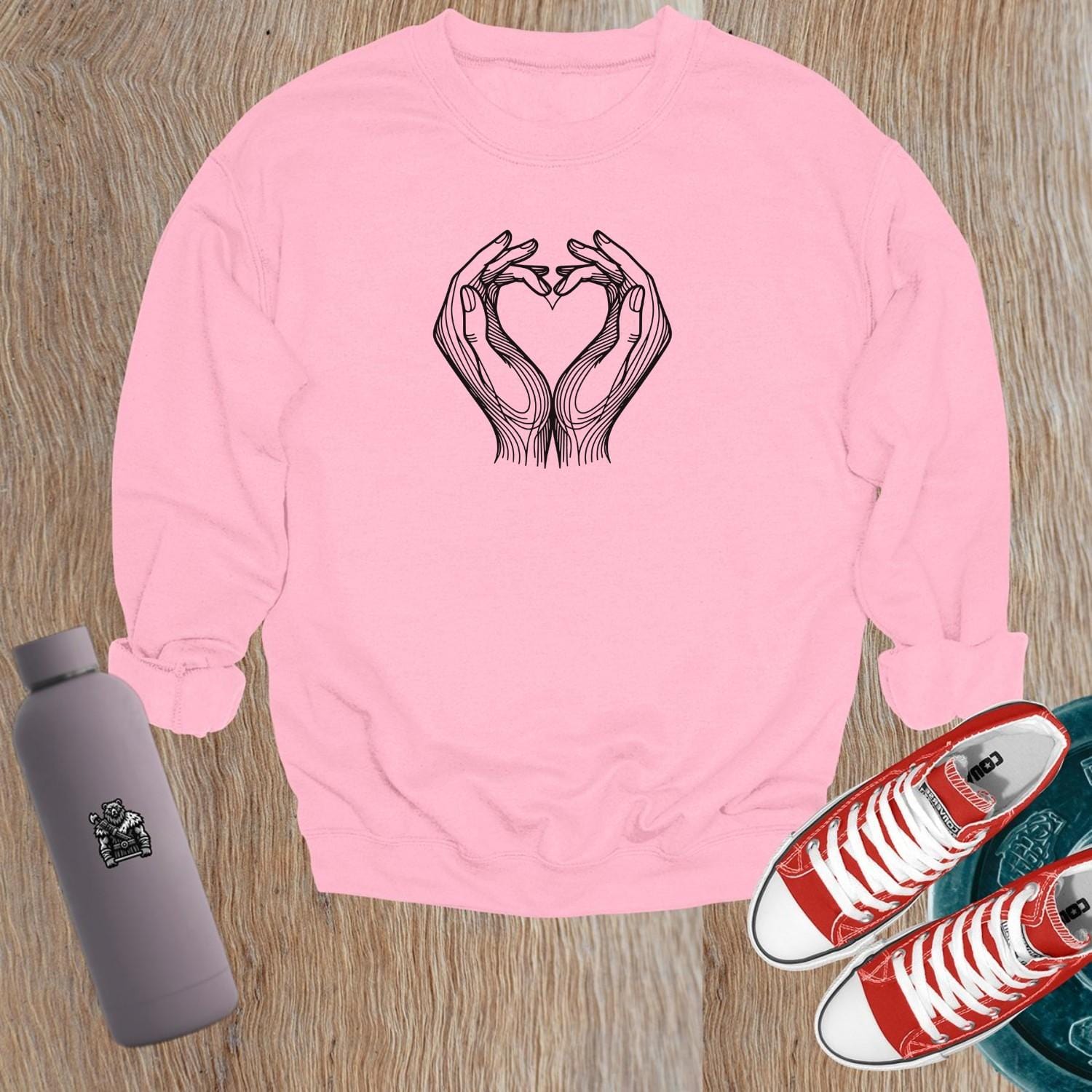 "Stylish gym sweatshirt featuring a heart formed by hands, perfect for fitness lovers. Comfortable, trendy activewear for workouts."