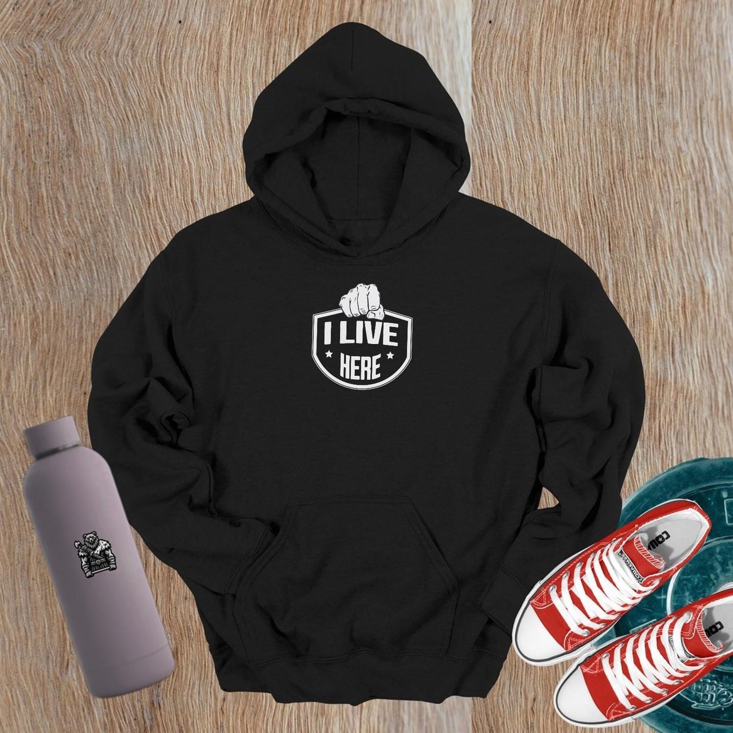 "Black gym hoodie featuring bold 'I Live Here' graphic, symbolizing strength and community. Perfect for workouts or casual wear."