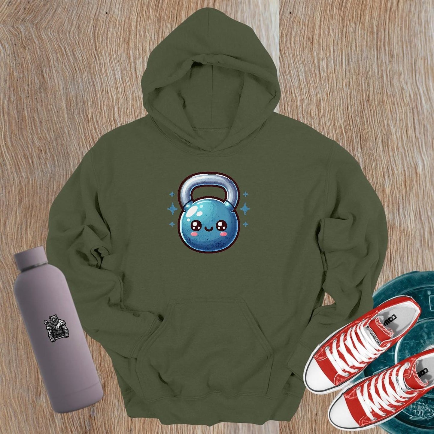 "Adorable fitness hoodie featuring a smiley kettlebell graphic, perfect for workouts or casual wear. Stylish and cozy gym apparel."