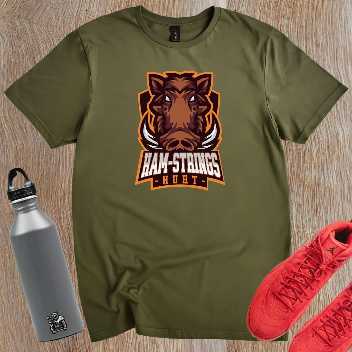 Alt text: "Bold gym T-shirt featuring a fierce wild boar graphic with the text 'Ham-Strings Hurt,' ideal for dedicated fitness enthusiasts."