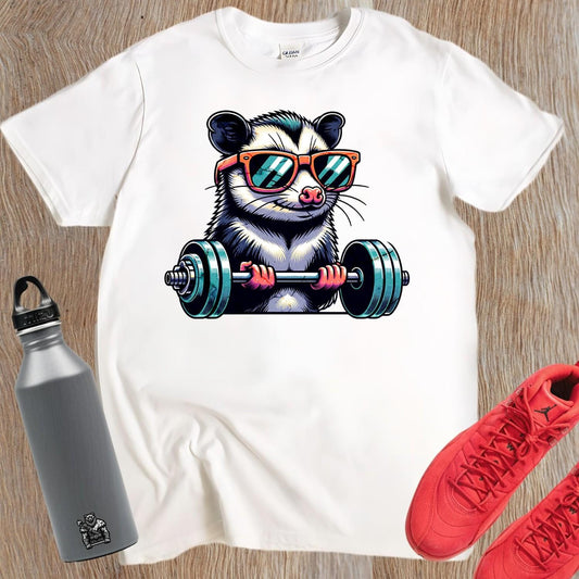 "Playful gym T-shirt featuring a cool possum lifting weights in stylish sunglasses, perfect for fitness enthusiasts and workout motivation."