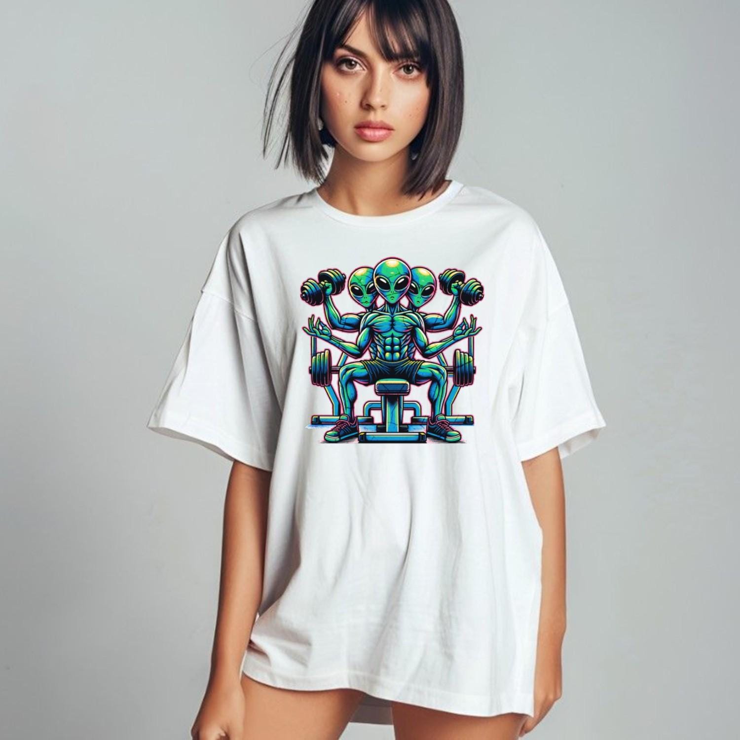 "Colorful graphic of powerful aliens lifting weights on a gym t-shirt, inspiring fitness goals and showcasing unique workout style."