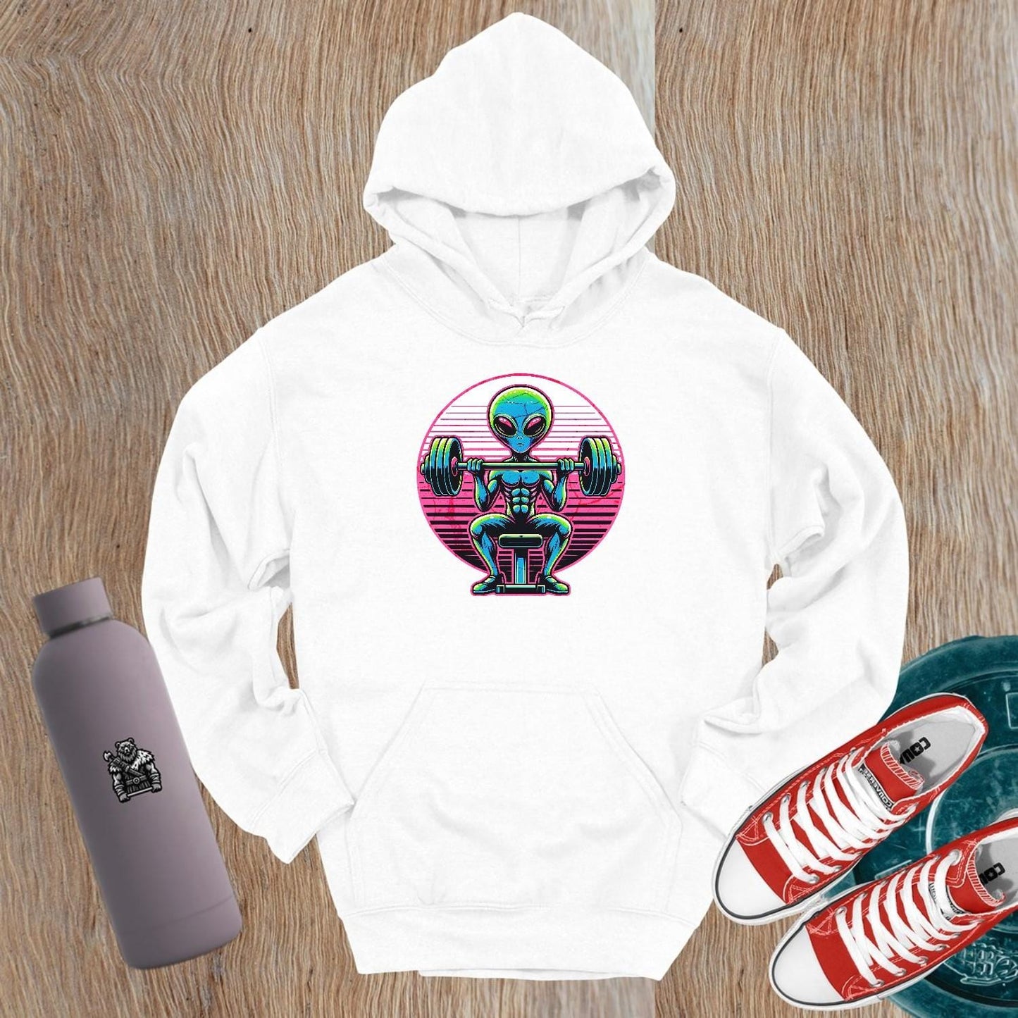 "Vibrant Alien Muscle Hoodie featuring a determined extraterrestrial lifting weights, perfect for gym enthusiasts and fitness lovers."
