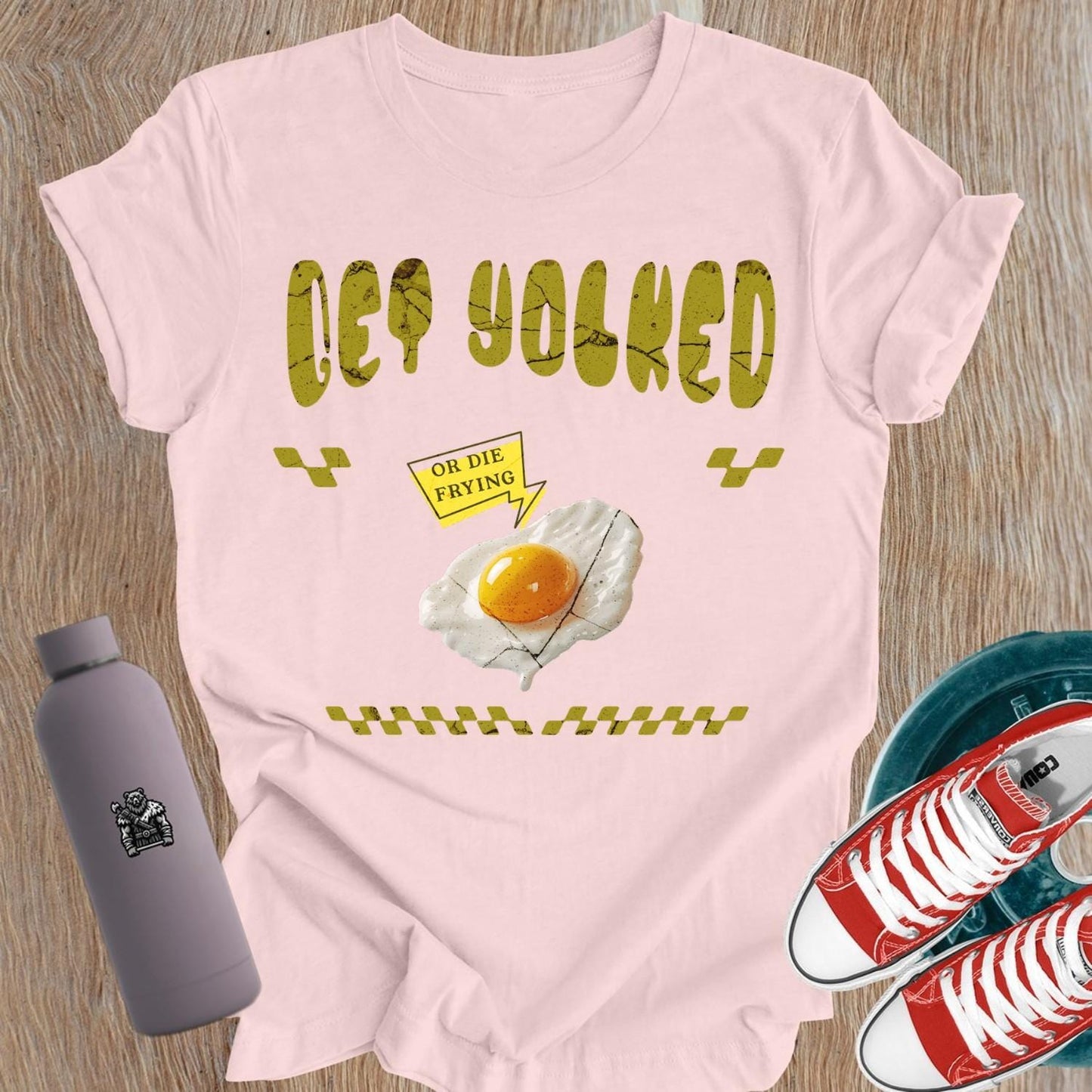 "Graphic T-shirt for women showcasing 'Get Yolked' slogan, featuring a weightlifting design, perfect for fitness enthusiasts and gym lovers."