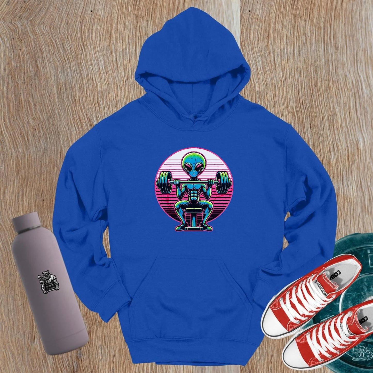 "Vibrant Alien Strength Hoodie featuring a bold alien lifting weights design, perfect for gym enthusiasts seeking unique workout apparel."