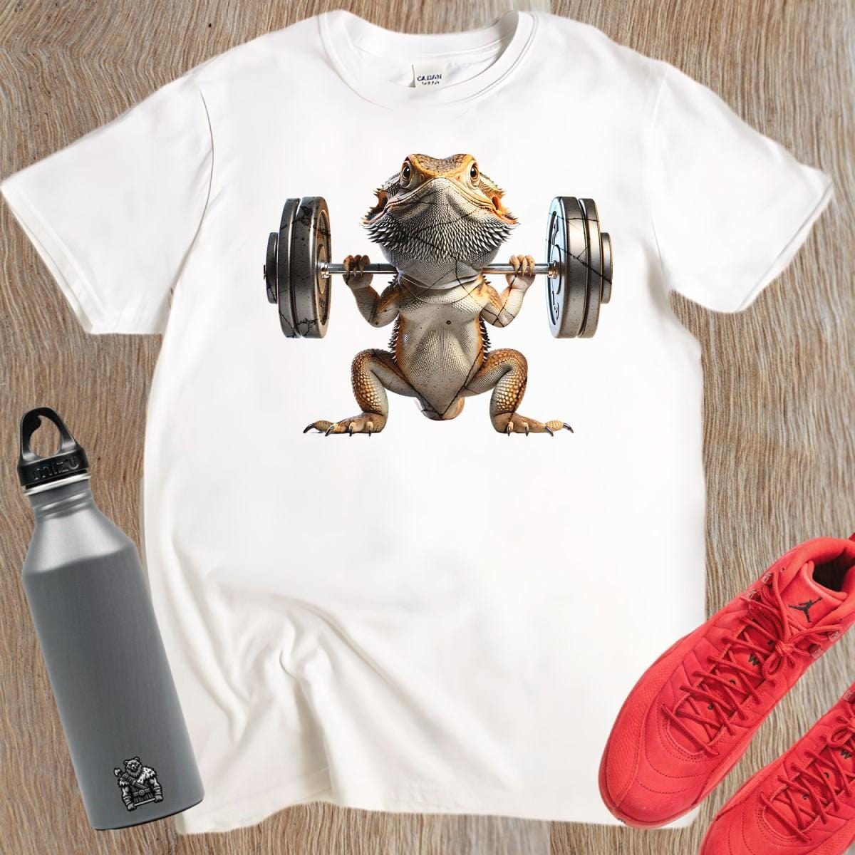 "Gym t-shirt featuring a vibrant lizard lifting weights, showcasing strength and individuality, ideal for gym enthusiasts and reptile lovers."