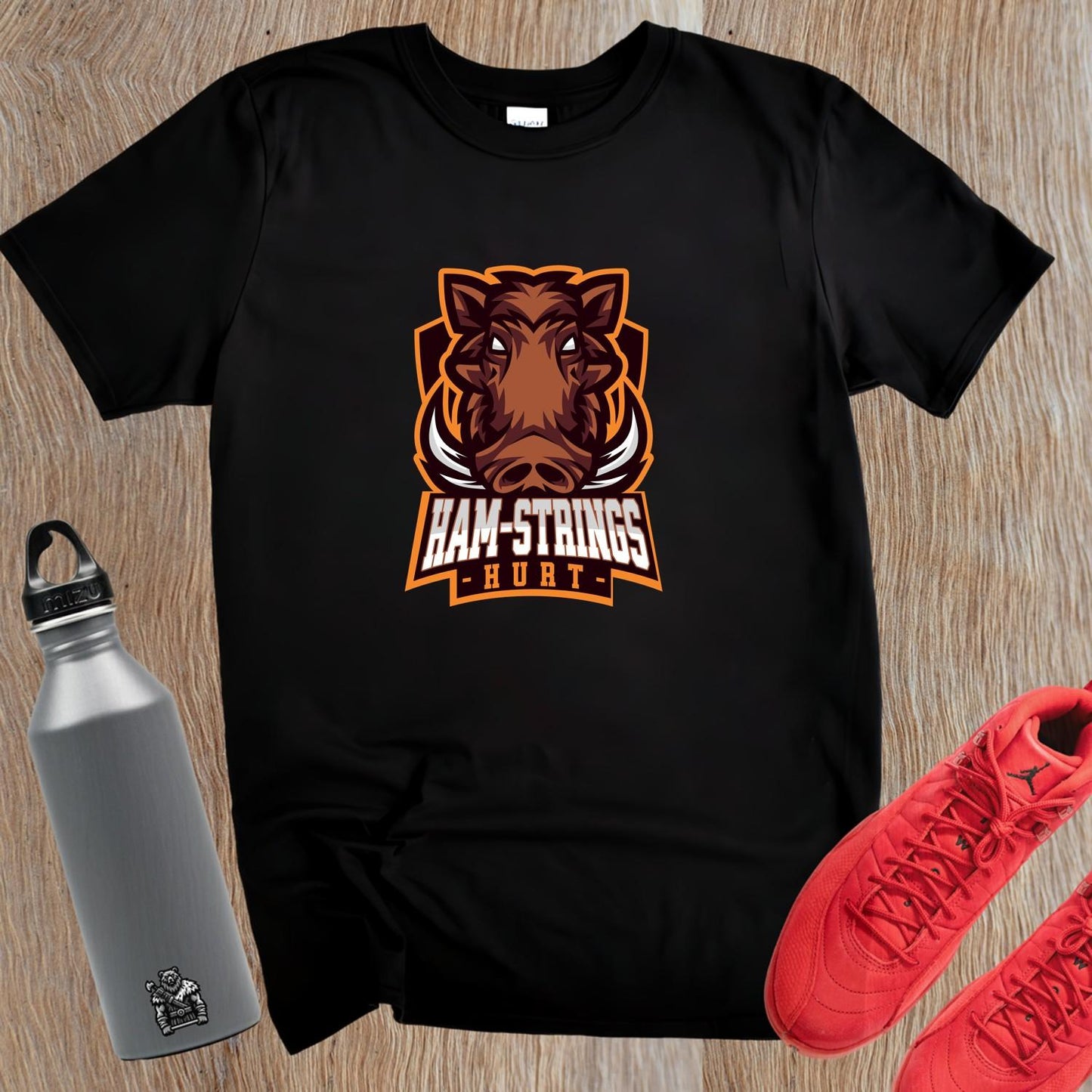 Alt text: "Bold gym T-shirt featuring a fierce wild boar graphic with the text 'Ham-Strings Hurt,' ideal for dedicated fitness enthusiasts."