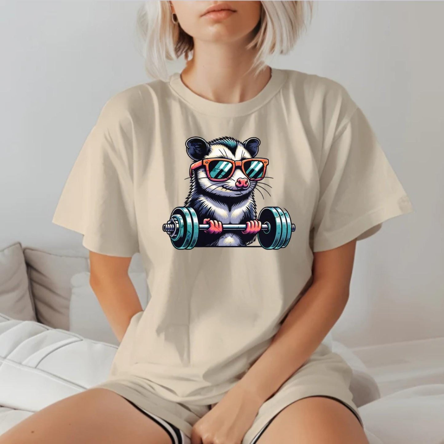 "Playful gym T-shirt featuring a cool possum lifting weights in stylish sunglasses, perfect for fitness enthusiasts and workout motivation."
