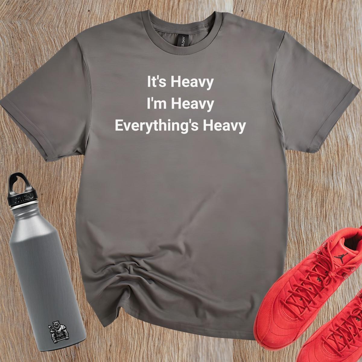 Alt text: "Bold black and white gym T-shirt featuring the motivational phrase 'It's Heavy, I'm Heavy, Everything's Heavy' for fitness enthusiasts."