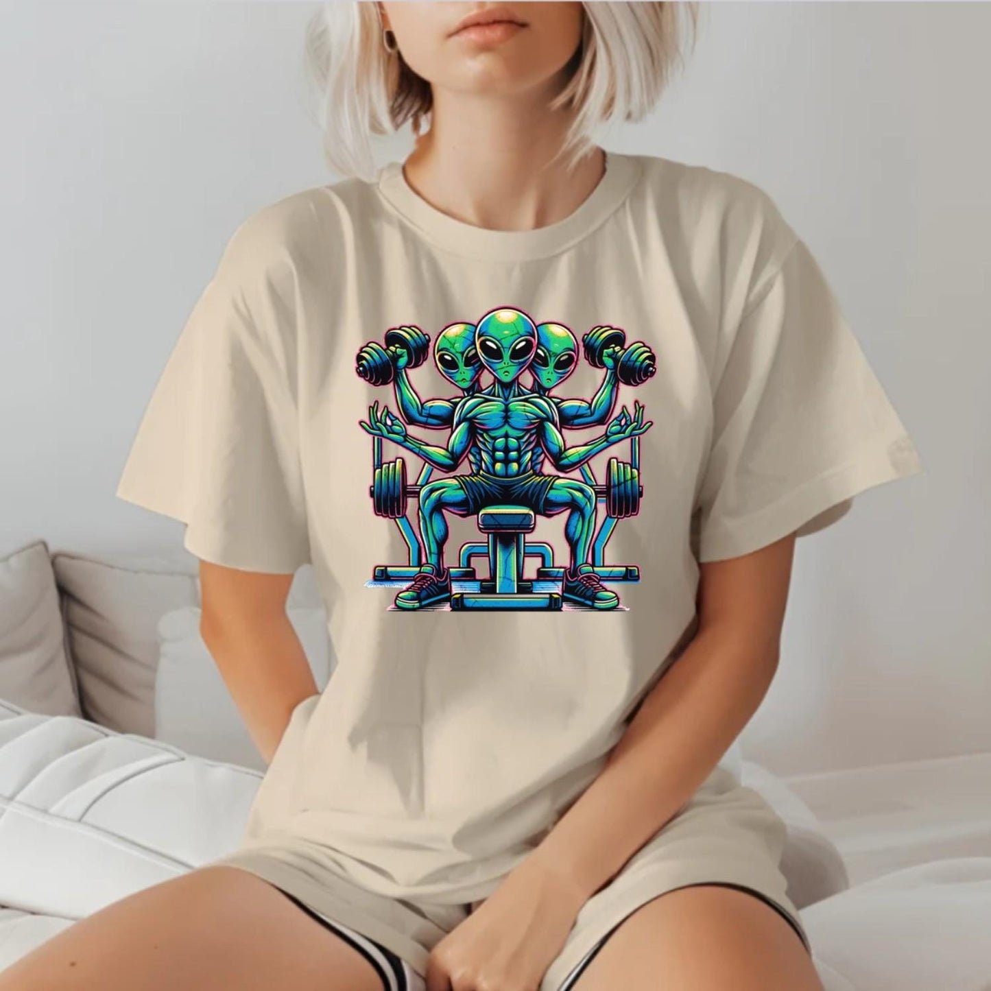 "Colorful graphic of powerful aliens lifting weights on a gym t-shirt, inspiring fitness goals and showcasing unique workout style."