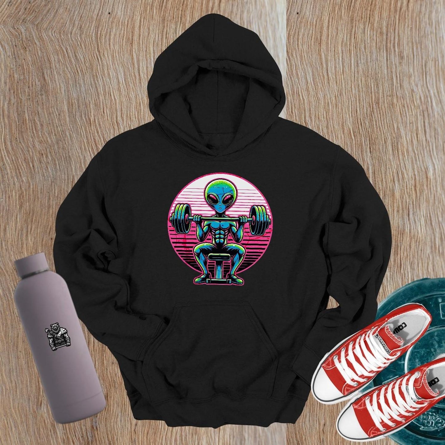 "Vibrant Alien Strength Hoodie featuring a bold alien lifting weights design, perfect for gym enthusiasts seeking unique workout apparel."