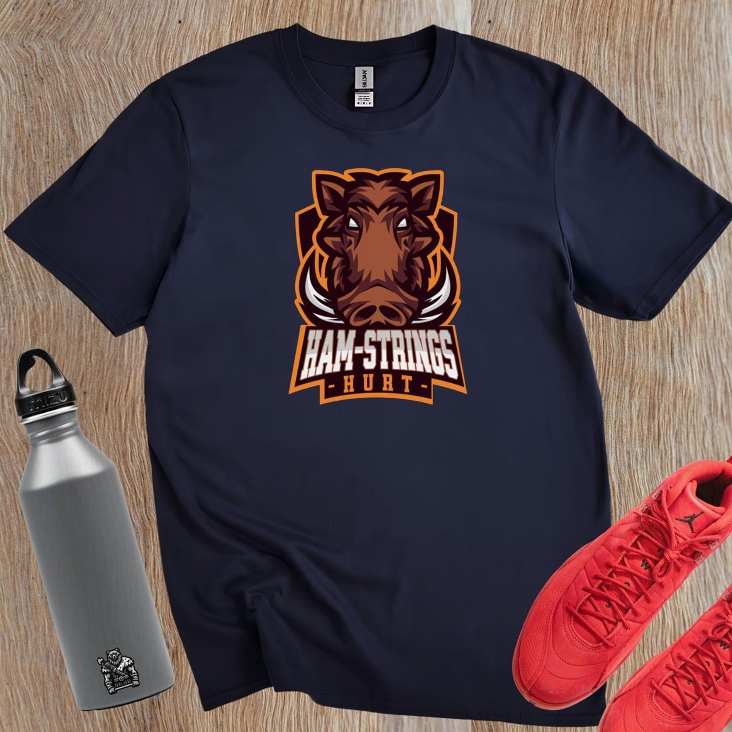 Alt text: "Bold gym T-shirt featuring a fierce wild boar graphic with the text 'Ham-Strings Hurt,' ideal for dedicated fitness enthusiasts."