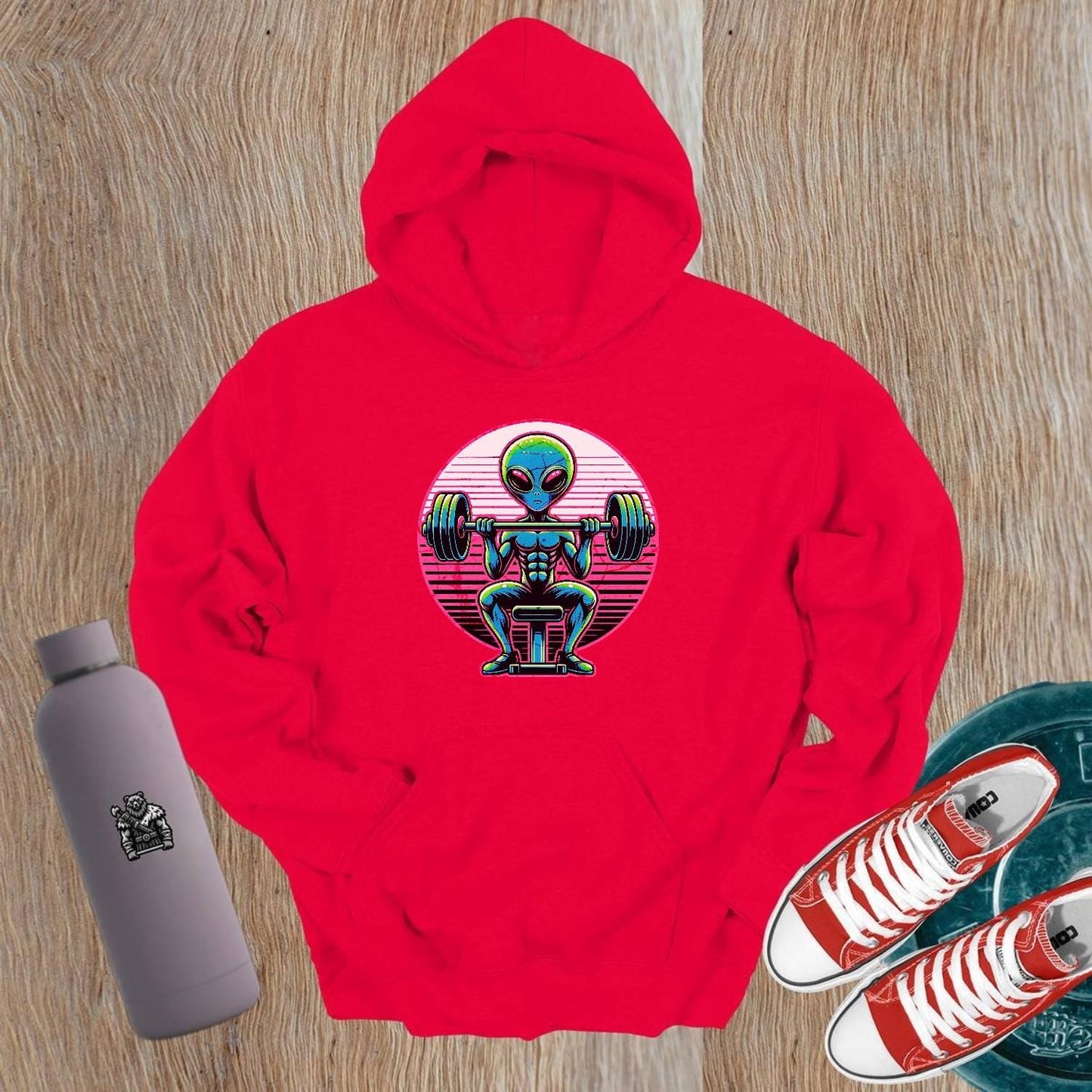 "Vibrant Alien Strength Hoodie featuring a bold alien lifting weights design, perfect for gym enthusiasts seeking unique workout apparel."