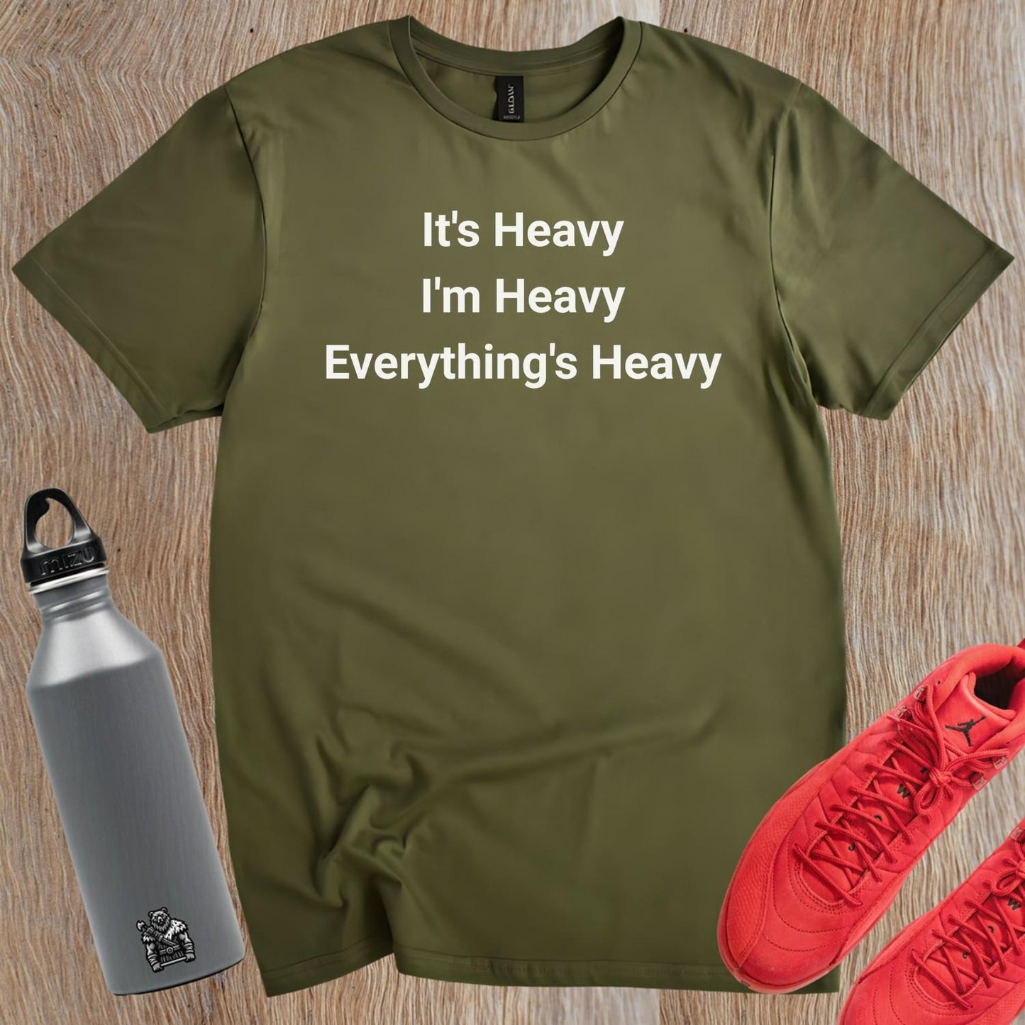 Alt text: "Bold black and white gym T-shirt featuring the motivational phrase 'It's Heavy, I'm Heavy, Everything's Heavy' for fitness enthusiasts."