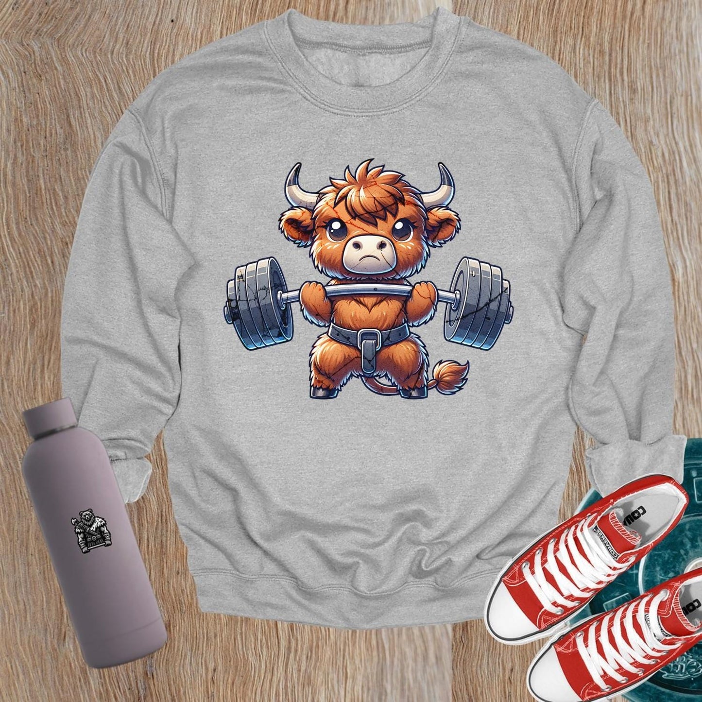 Alt text: "Vibrant gym sweatshirt featuring a cute highland cow lifting weights, promoting fitness goals and a healthy lifestyle. Perfect for workouts."