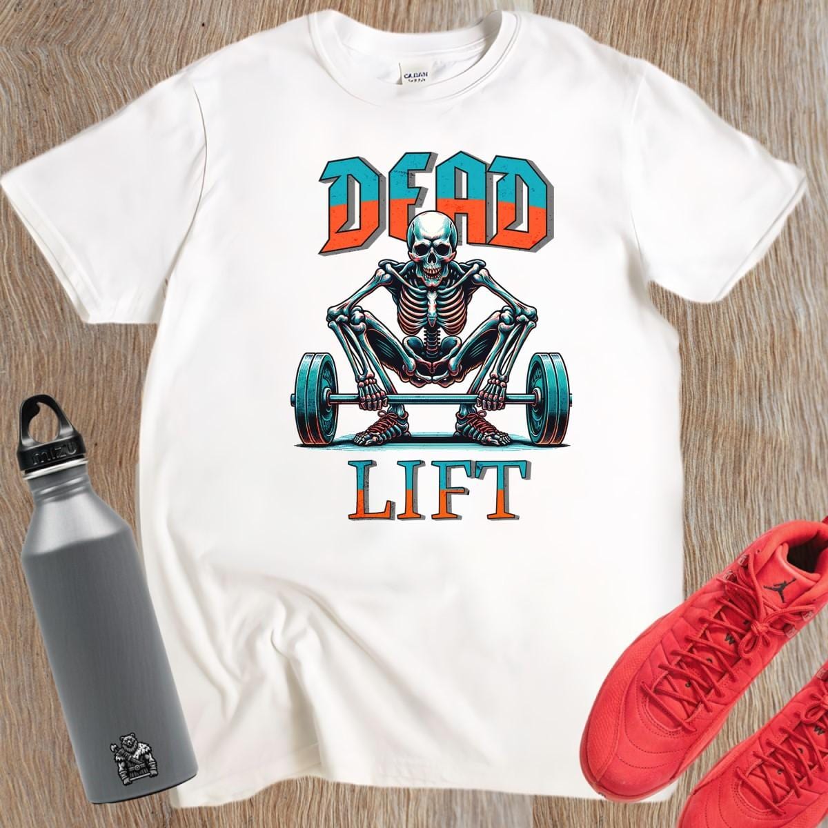 "Graphic T-shirt featuring a skeleton lifting weights, perfect for fitness enthusiasts. Bold design ideal for gym workouts and casual wear."